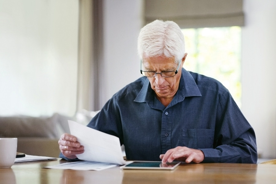 elder looking at bills and making calculations of long term care costs